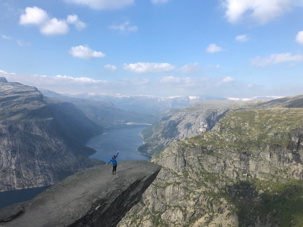 Trolltunga Norway hike woman cliff lake glacier fjord hiking trail August